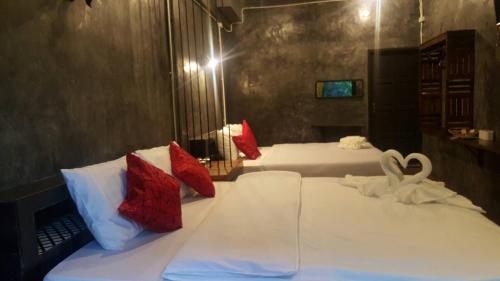 two beds in a room with two swans on them at Keeree Loft Resort คีรีลอฟท์รีสอร์ท in Thong Pha Phum