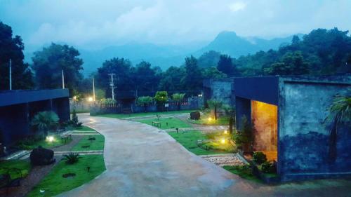 a view of a courtyard with mountains in the background at Keeree Loft Resort คีรีลอฟท์รีสอร์ท in Thong Pha Phum