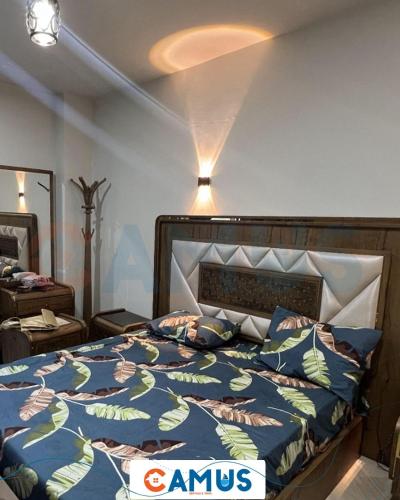 a bedroom with a bed with a blue comforter at CAMUS 343, Princess Resort in Hurghada