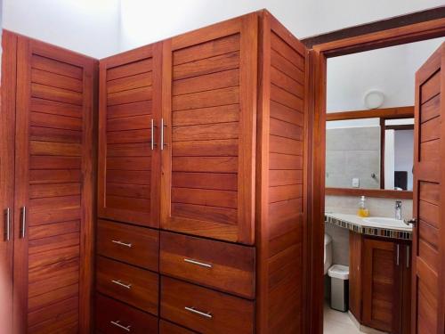 a bathroom with wooden cabinets and a sink at Casa ONCE ONCE in Villa de Leyva