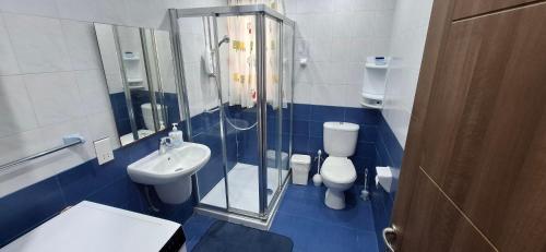 a bathroom with a shower and a toilet and a sink at Seafront Apartment - Balcony over the Harbour in Marsaskala