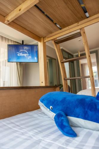 a blue stuffed animal laying on a bed at The Delfini Hua Hin in Hua Hin