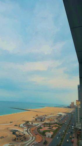 an aerial view of a beach and a highway at Beachfront Luxury Family Apartment with Pool, Gym, Jacuzzi - AJMAN Corniche UAE in Ajman
