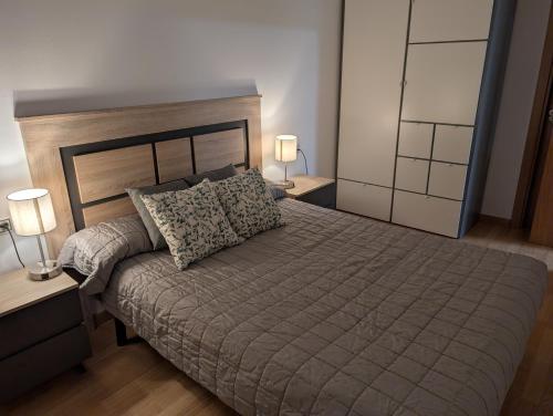 a bedroom with a large bed with two lamps on tables at IM80 in Montroig