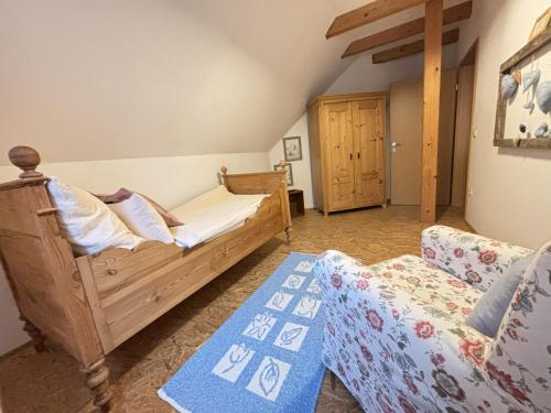 a bedroom with a wooden bed and a couch at Ferienhaus Feistritz in Feistritz ob Bleiburg