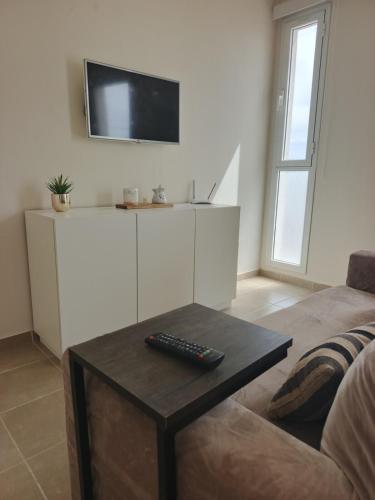 a living room with a couch and a remote control on a table at Depto tranquilo y equipado cerca del mar in Puerto Madryn