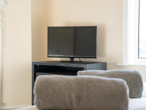 a living room with two chairs and a television at Chestnut Lodge Bed & Go in Eastleigh