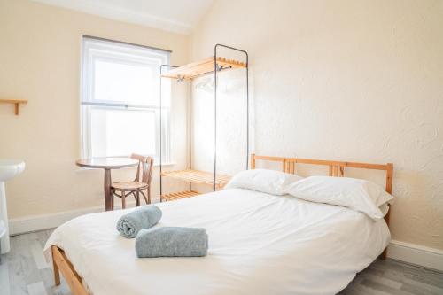 a bedroom with a white bed with two towels on it at Chestnut Lodge Bed & Go in Eastleigh