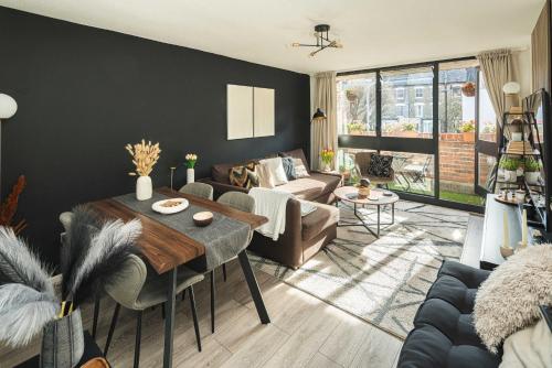 a living room with a couch and a table at Spacious and modern flat in Archway in London