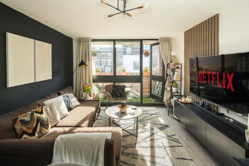 a living room with a couch and a tv at Spacious and modern flat in Archway in London