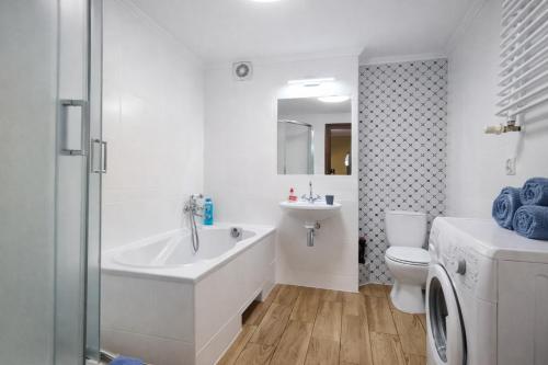 a bathroom with a tub and a toilet and a sink at Apartament przy Walowej in Łańcut