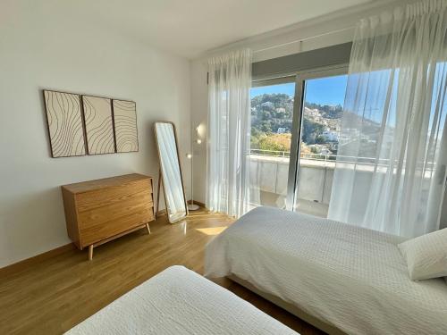 a bedroom with two beds and a dresser and a window at Althaia Hills - Precioso adosado con terraza panorámica al mar y montaña in Altea