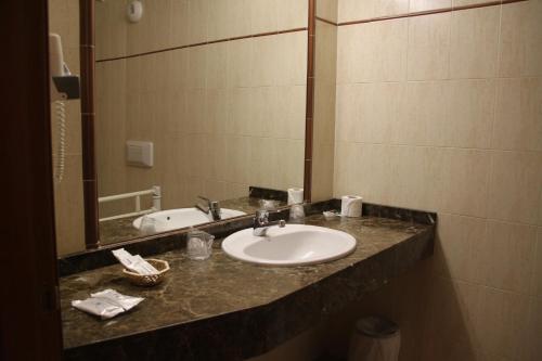 a bathroom counter with a sink and a mirror at Hotel Soldeu Maistre in Soldeu