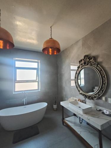 a bathroom with a white tub and a mirror at HOTEL MI SOLAR EJECUTIVO in Uruapan del Progreso