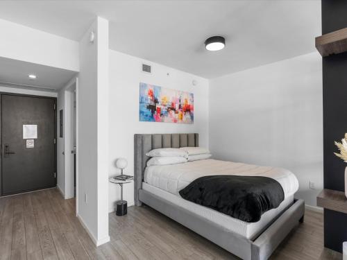 a bedroom with a bed and a painting on the wall at 29th Floor Balcony Studio Miami Skyline Views in Miami