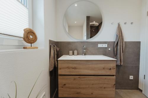 a bathroom with a sink and a mirror at Ferienhaus HeimatLay in Mörsdorf