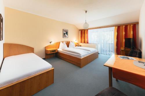 a hotel room with two beds and a desk at B&B Number 1 in Loipersdorf bei Fürstenfeld