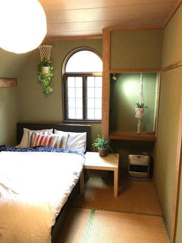 a bedroom with a bed and a window at A short walk to Akakura Onsen Ski Lift and Town by Japow House in Myoko