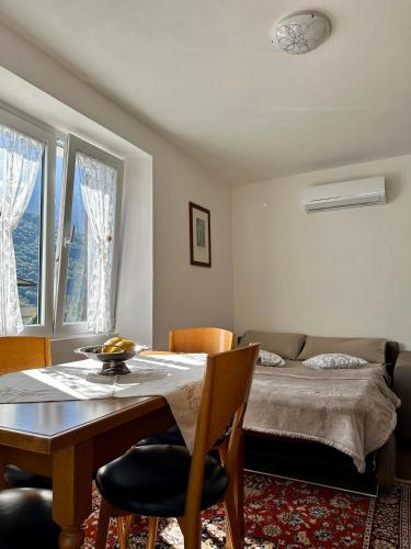 a living room with a table and a bed at Casa Verde Valsassina 2 in Primaluna