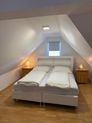 a bedroom with a white bed in a attic at AdiFerienwohnung in Gerolstein