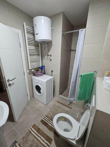 a bathroom with a toilet and a washing machine at Garden Doboj in Doboj