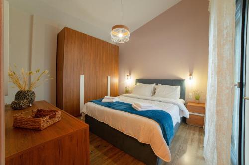 a bedroom with a large bed and a wooden cabinet at Modern house! in Iráklia