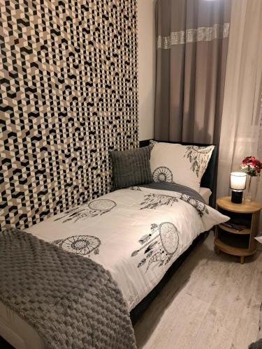 a bedroom with a bed with a patterned wall at JULIA Apartament- Oświęcim in Oświęcim