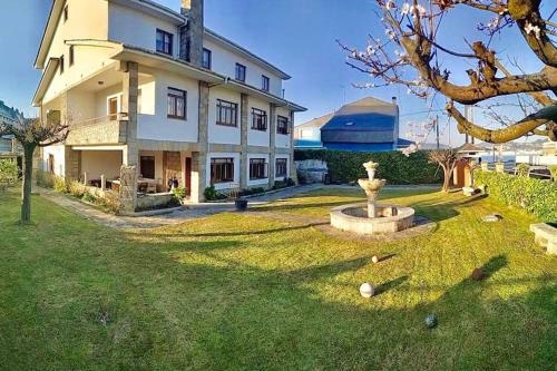 a large house with a fountain in the yard at Covas Beach Ocean in Lago