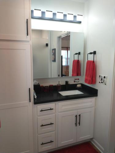 a white bathroom with a sink and a mirror at Garden Guest Cottage in Harrisonburg