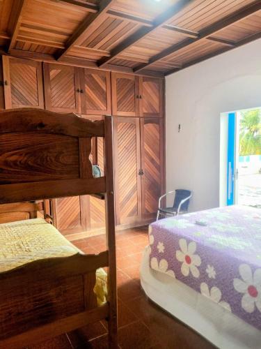 a bedroom with two bunk beds and wooden cabinets at Casa com Piscina Grande em Salinas in Salinópolis