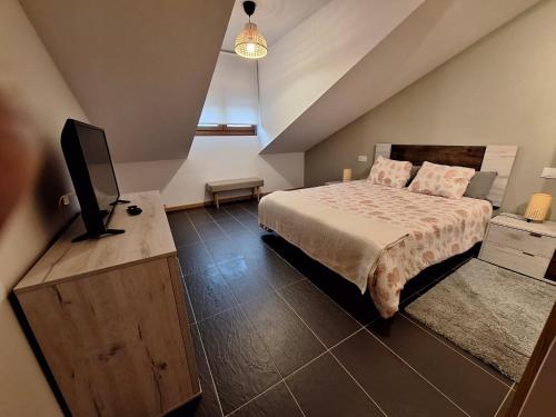 a bedroom with a bed and a flat screen tv at Aldea Bricia 16 in Posada de Llanes