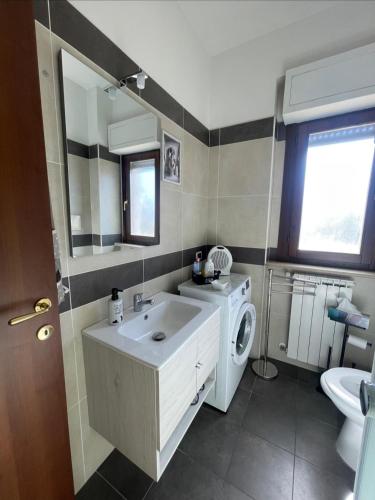 a bathroom with a sink and a washing machine at Il Giardino di Luna in Poggio Nativo