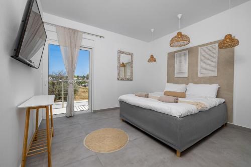 a bedroom with a bed and a large window at Villa Pastida - Boutique Luxury Villa on Rhodes with Private Pool in Pastida