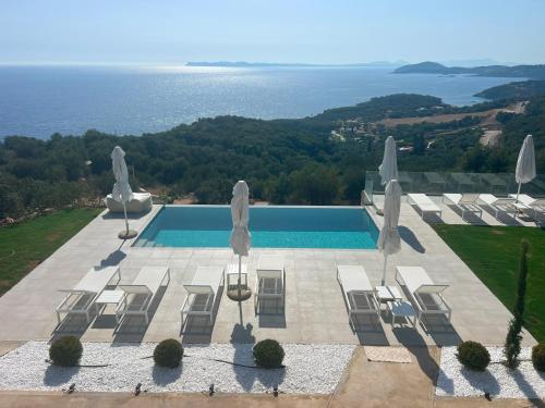an aerial view of a swimming pool with chairs and umbrellas at Villa Veneti in Pérdika