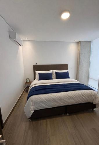 a bedroom with a large bed with blue pillows at Apartment in Torre Empiria in Torreón