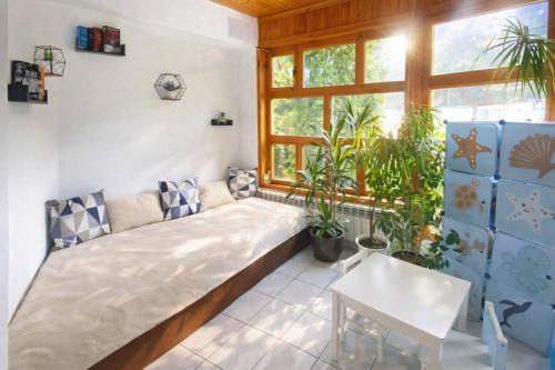 a bed in a room with plants and a window at Къща за гости Бели Вит in Ribarica