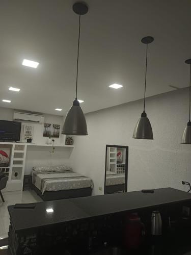 a bedroom with a bed and three pendant lights at Monoambiente Dos Lunas in Resistencia