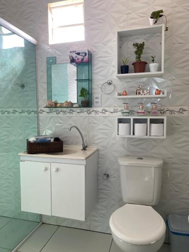 a white bathroom with a toilet and a shower at Casa Solmar Guriú in Guriú