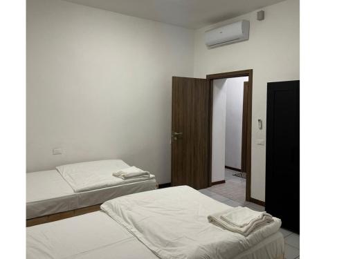 a room with two beds and a closet with a door at Fiore Apartments in Fiorenzuola dʼArda