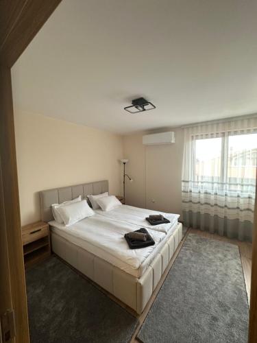 a bedroom with a large white bed and a window at Martin's Apartment in Bansko