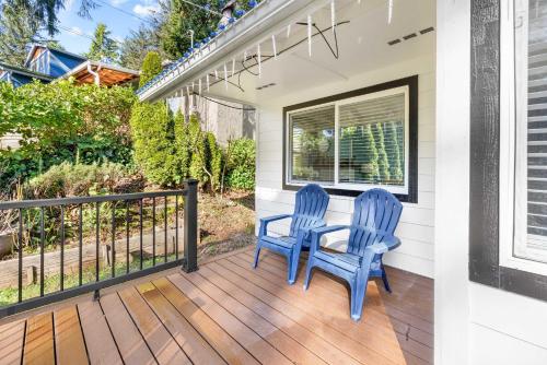 two blue chairs sitting on the porch of a house at Bright Beach Town Bungalow in Gleneden Beach