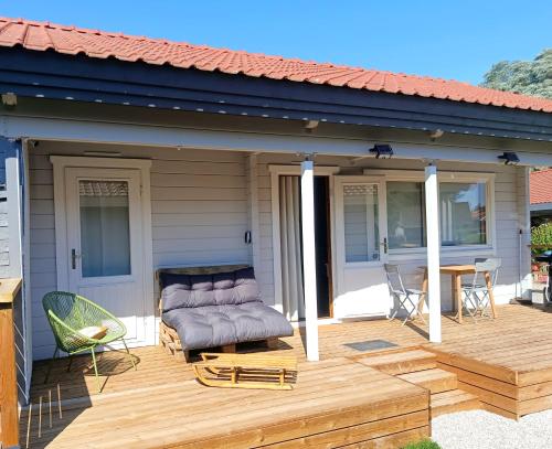 a patio with a couch on a wooden deck at "Kota coeur de bois" Chalet en bois au domaine de l'Aa in Bourbourg