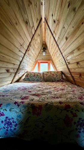 a large bed in a wooden room with a window at Chalé Serra Furada - vista única da Serra Furada in Grão Pará