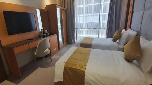 a hotel room with two beds and a flat screen tv at فندق الريان Ryan Hotel in Jeddah