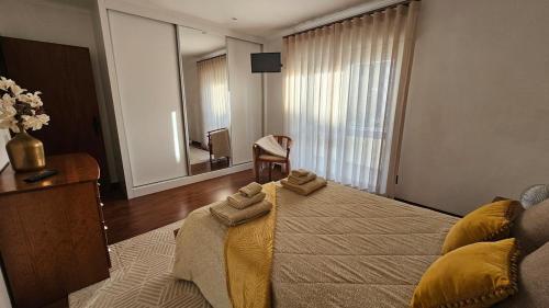 a bedroom with a large bed with towels on it at Varanda da Gardunha - Alojamento Local in Fundão