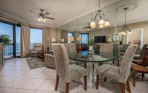 a dining room with a glass table and chairs at Phoenix VI 61509 in Orange Beach
