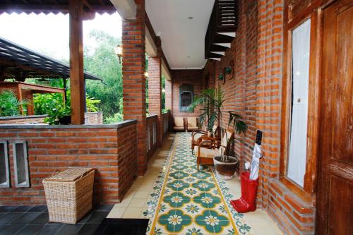 a porch with a rug on a brick building at Joglo Mandapa Boutique Hotel in Yogyakarta