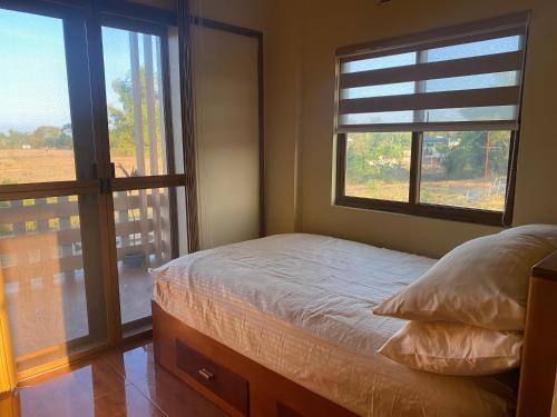a bedroom with a bed and a large window at Balai Moca Hillside with Sunset View in San Juan