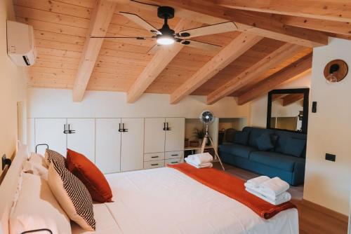 a bedroom with a large bed and a blue couch at Tims Vista Bella - Mezzegra, Tremezzina by LoveComo in Lenno