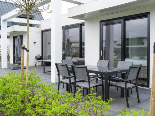 a patio with a black table and chairs at Harderwold Villa - 551 in Zeewolde